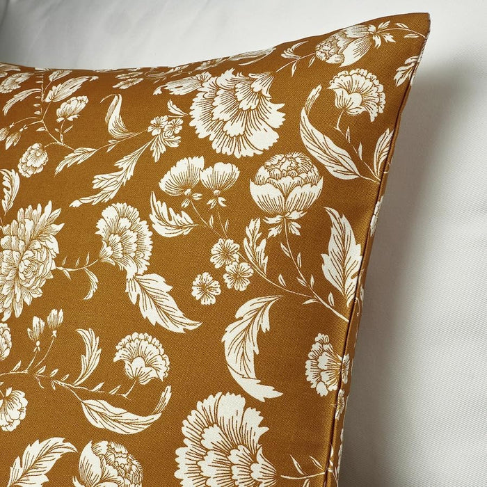 Detailed view of mustard floral cushion with visible stitching placed on light fabric surface – 20570990