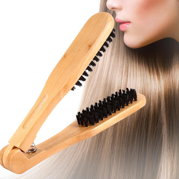 Wooden hairbrush with black bristles being used on a person's hair against a white background