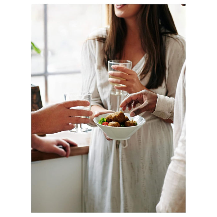 Person receiving a bowl of food from another person in a casual setting.