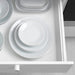 Set of white ceramic plates stacked in a drawer