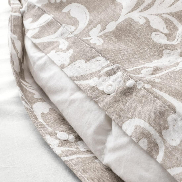 Close-up of beige and white floral patterned fabric with button closure. Highlighting the IKEA VÅRBRÄCKA Duvet Cover and Pillowcase, elegant and stylish bedding-00412614, 10424225 