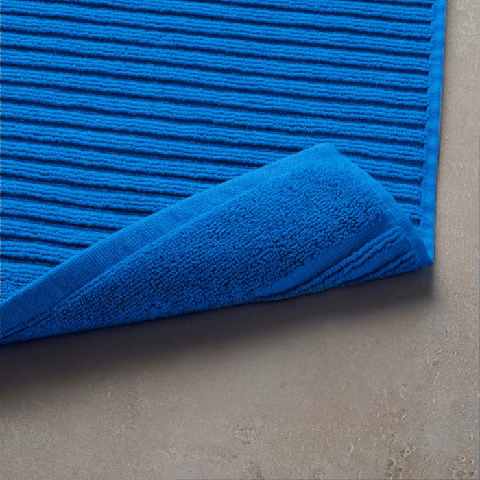 Blue textured rug on a beige floor