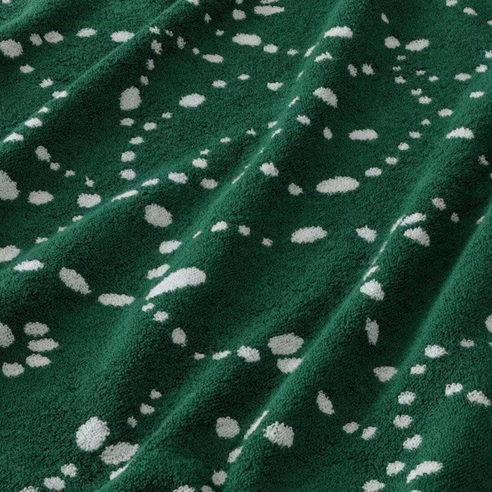 Green fabric with white polka dot pattern