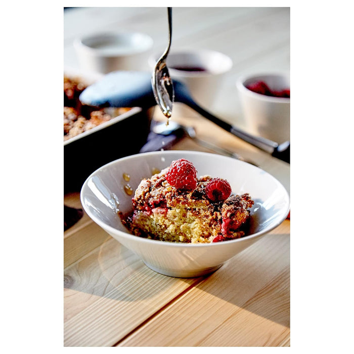 White bowl with berry dessert on a wooden table