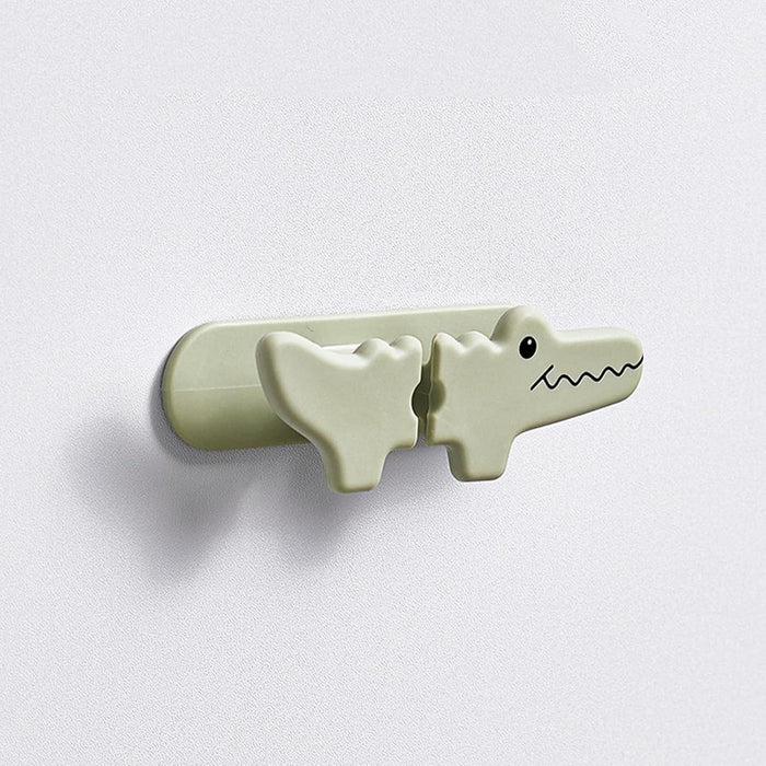 Light green crocodile-shaped hook on a white background