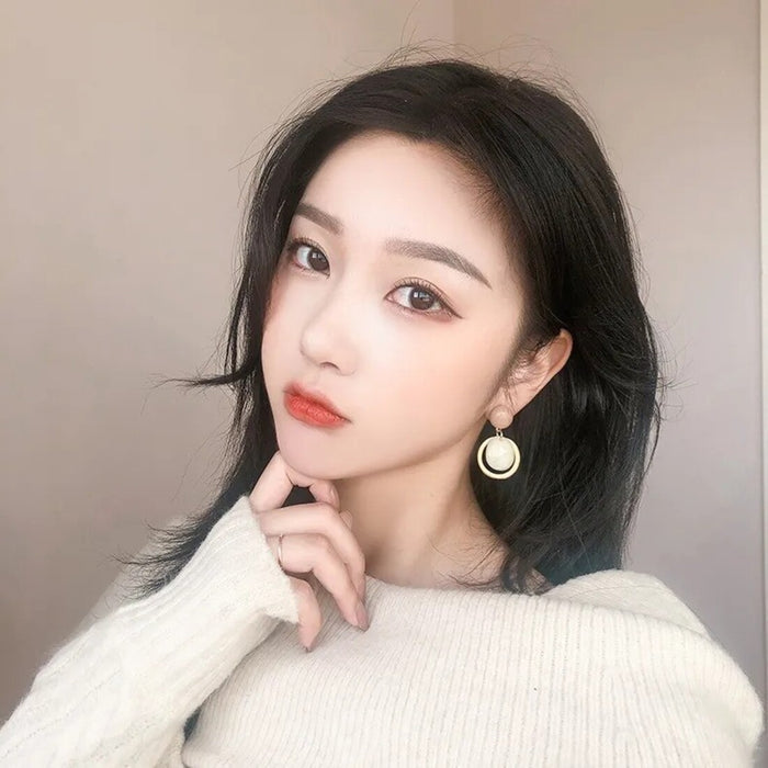 Woman wearing a white sweater with a neutral background