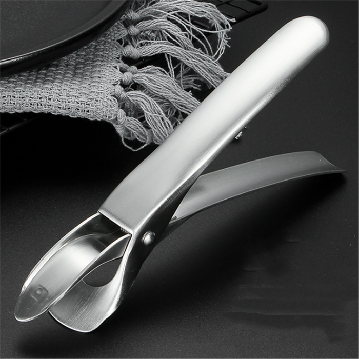 Anti-scalding clip placed next to cookware on a kitchen counter