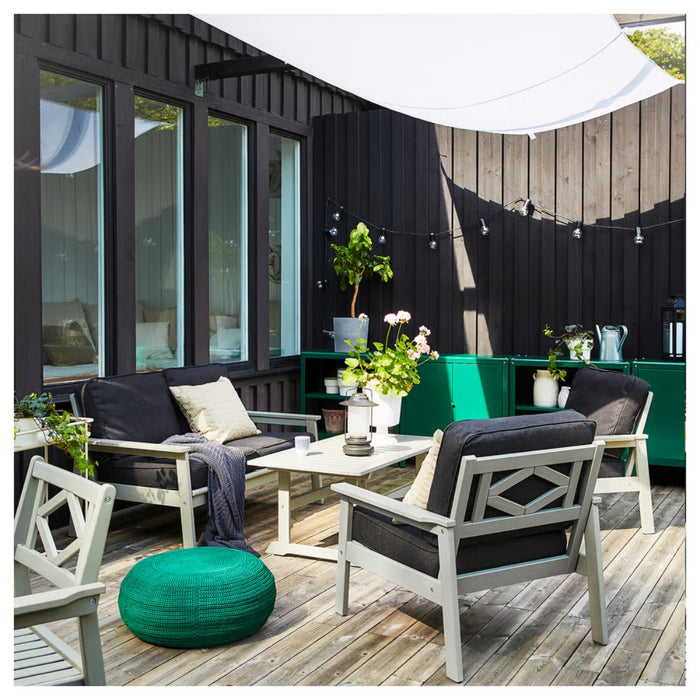 Outdoor patio with furniture and decor against a modern building.