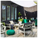 Outdoor patio with furniture and decor against a modern building.