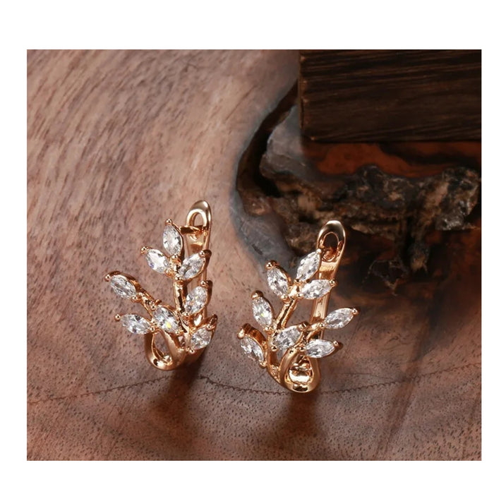 Rose gold wheat earrings – placed on wooden surface showing warm tone and sparkle