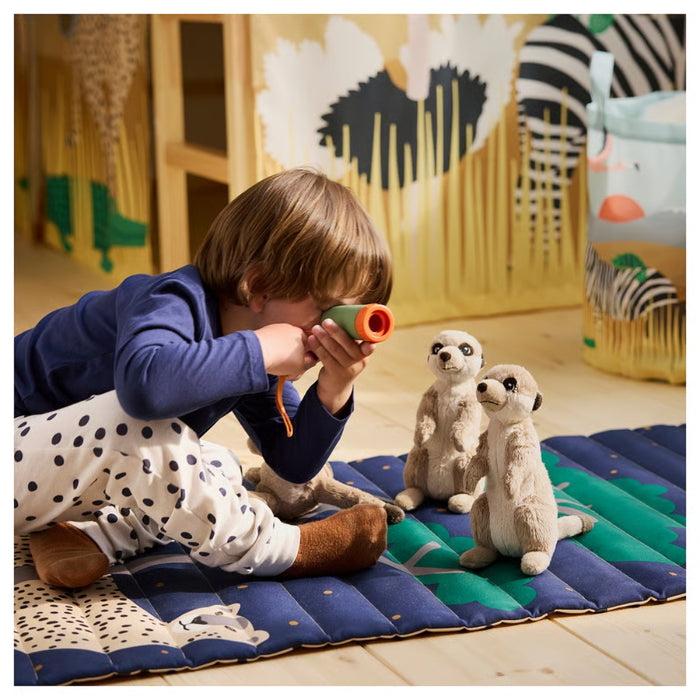 Child sitting on cheetah mat with toy monocular, playing with meerkat plush toys in wildlife-themed room