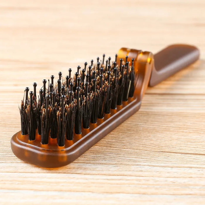 Brown hairbrush with bristles on a wooden surface