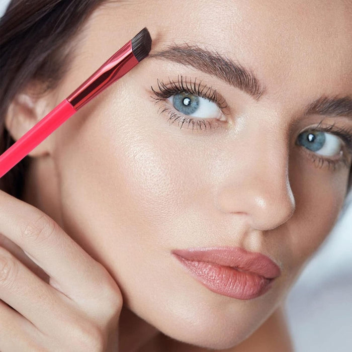 Close-up of woman using red angled eyebrow brush for precise brow shaping – highlights defined lashes, smooth skin, and natural makeup finish – 1598453751840 14041847