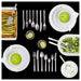 Dinner setting with green soup, pasta, and salad on a black background
