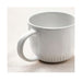 White ceramic mug on a textured surface with a light background