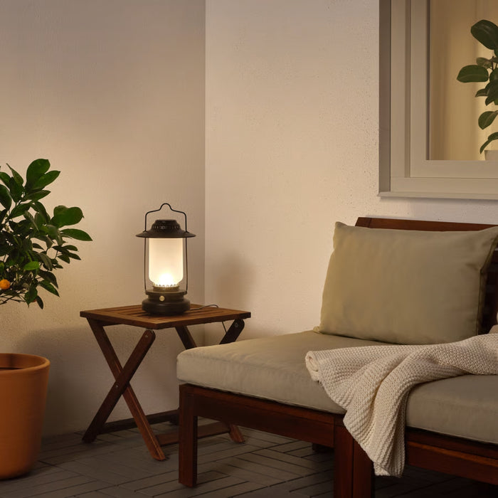 Cozy living room with a wooden chair, lantern, and potted plant.