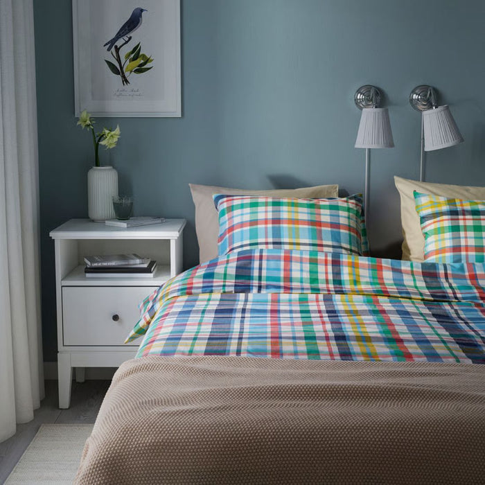 Bedroom with a colorful checkered bedspread and nightstands.