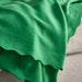 DAGGKÅPOR throw, green, 130x170 cm. Soft textured fabric with scalloped edge draped over light grey sofa – adds elegant, cosy accent to living space – 90602695.