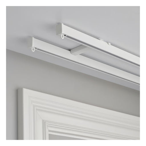 White ceiling-mounted light fixture on a gray wall with a white door in the foreground.