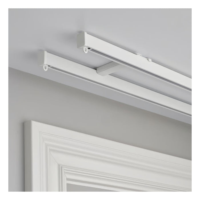 White ceiling-mounted light fixture on a gray wall with a white door in the foreground.