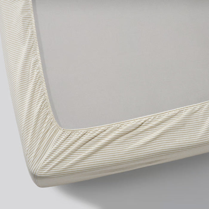 Close-up of a fitted sheet with a subtle pattern on a bed corner.