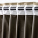 Brown curtains with white and beige trim on a rod