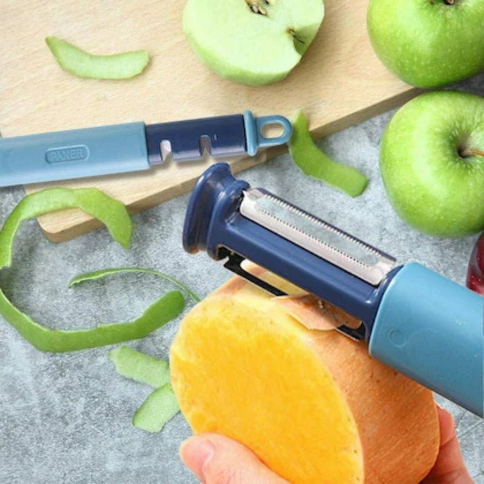 Blue vegetable peeler peeling an orange with green apples in the background