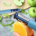 Blue vegetable peeler peeling an orange with green apples in the background