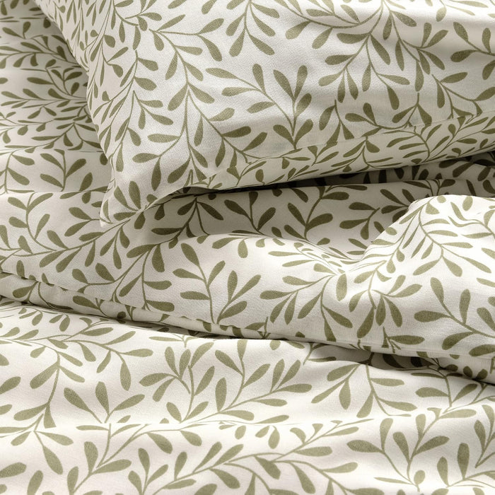 Close-up of SORGMANTEL green leafy print on white cotton fabric