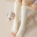 Close-up of cream plush leg warmers worn below knees with numbered fit indicators - 