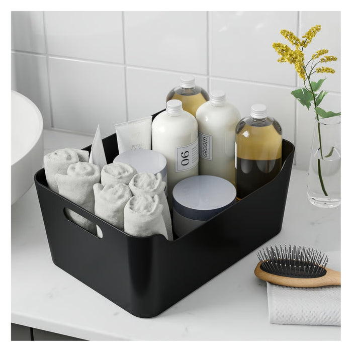 Black storage basket with bath products on a bathroom counter