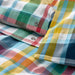 Close-up of a colorful plaid fabric with a button.