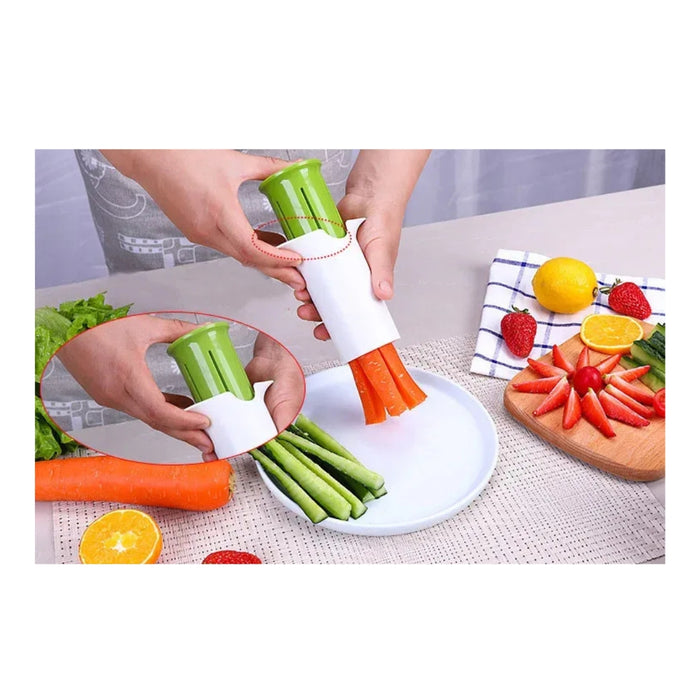 Vegetable peeler being used to peel carrots and celery on a white plate with a kitchen setting in the background.