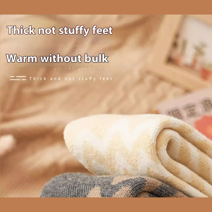 Close-up of two rolled towels with zigzag patterns in beige and gray on soft surface