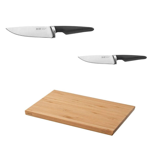 Two knives with black handles and a wooden cutting board on a white background