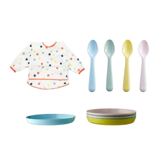 Colorful baby bib, plates, and spoons on a white background