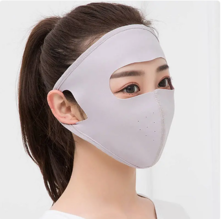 Person wearing a gray face mask with a plain background