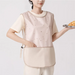 Person wearing a beige apron holding a tray with food on a plain background