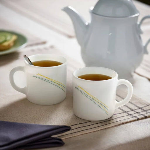 IKEA SKRÄNTÄRNA stripe cups with gold lines beside a grey kettle in a tea setting