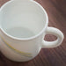 IKEA SKRÄNTÄRNA white glossy stripe cup with handle on a wooden table