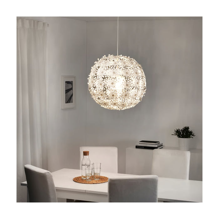 Modern dining room with a spherical pendant light, table, chairs, and decor items.