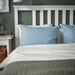 IKEA ÄNGSLILJA blue-grey pillowcases styled on bed in cosy bedroom headboard nook