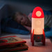 IKEA AFTONSPARV rocket lamp glowing softly on bedside table as night light