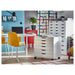 Modern home office with white ALEX drawer units on black castors, yellow chairs, blue accent wall