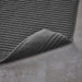 IKEA ALSTERN dark grey bath mat and matching towel displayed on concrete floor bathroom setting