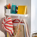 IKEA ALTARLIDEN white hook rack on cabinet door holding striped bag notebook and markers
