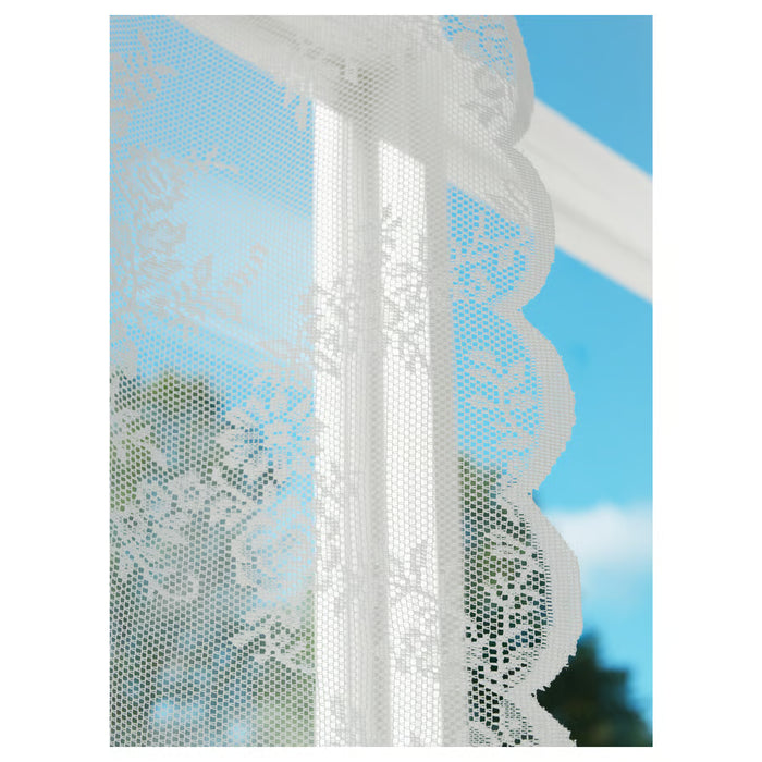 IKEA ALVINE SPETS white lace curtains hung at a blue window beside shelves, showing size and sheer fabric