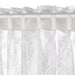 Close-up of IKEA ALVINE SPETS white curtain with delicate floral lace pattern and curved edges