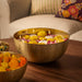 IKEA AROMATISK gold bowl styled with floating candles and yellow flowers on wooden table