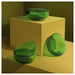 Two IKEA AROMATISK green glass bowls displayed on beige pedestal showing organic shape and polished finish